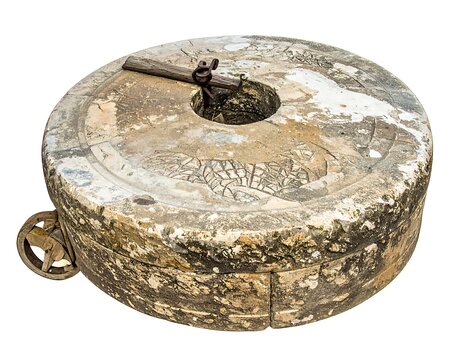 Circular stone millstone, with aged surfaces and centered hole, rests against a white background