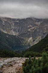 Morskie Oko lake nestled in the Tatra mountains under dramatic cloudy skies © WellStock