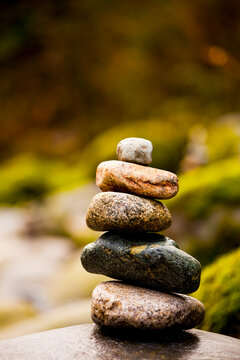 A stack of small rocks balanced on top of each other by a river.