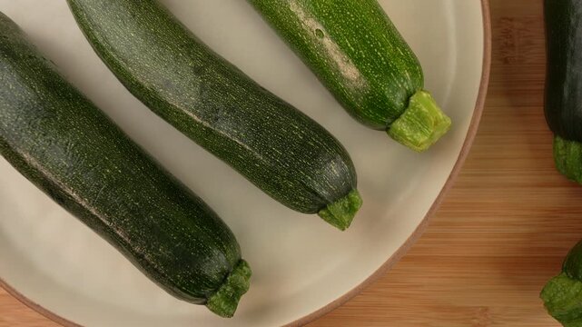 Fresh green zucchini on wooden background top view.