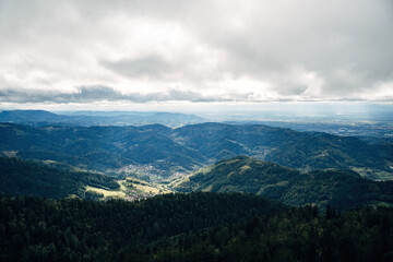 Fototapeta premium Spectacular Summer Valley View from a Mountain Peak, High-Altitude Panorama Overlooking Lush Green Meadows and Small Villages in Natural Daylight