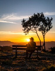 Obraz premium A serene silhouette of a person on a bench at sunset