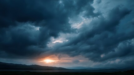 Dramatic stormy sky with a sunset glow over the mountains