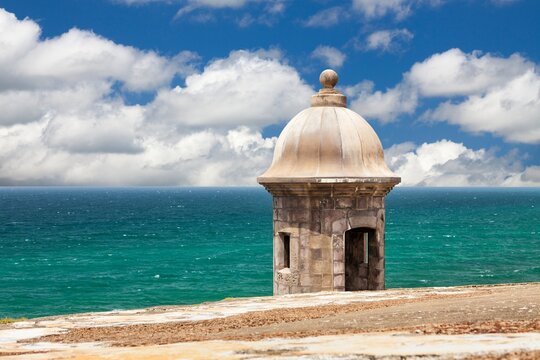 A historic stone sentry box stands watch over the Atlantic Ocean at Castillo San Felipe del Morro - part of the San Juan National Historic Site, Spanish colonial architecture.