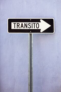 A black and white Spanish-language one-way traffic sign reading Transito, the arrow points to the right