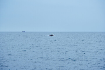 Solitary Boat Drifting on the Vast Blue Ocean, Minimalist Maritime Landscape under Bright Natural Sunlight