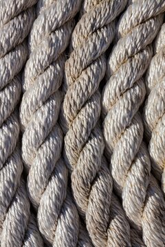 Tightly coiled rope on a dock at Charleston Marina, Oregon, showing detailed texture and nautical character.