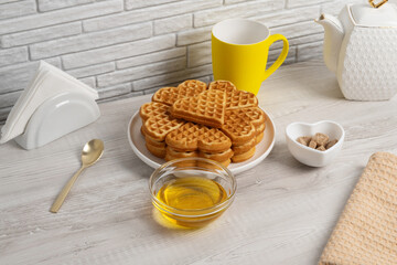 Waffles made in a heart shape served on a plate with honey