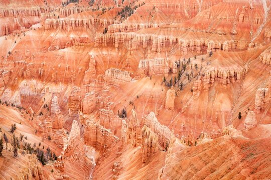 Vibrant red rock formations at Point Supreme, Cedar Breaks National Monument, view from above, erosion and weathering, creating a jagged landscape with deep clefts and layered sandstone cliffs.