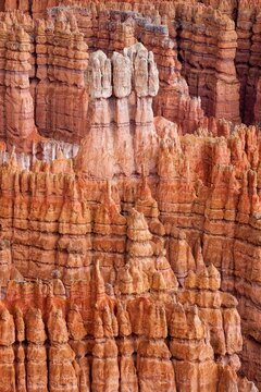 Eroded hoodoos in Bryce Canyon rise like ancient spires from the canyon floor, showcasing layers of vivid red and orange sandstone in southern Utah's iconic landscape.
