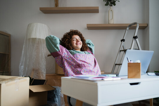 Relaxed woman taking a break at home workspace with laptop