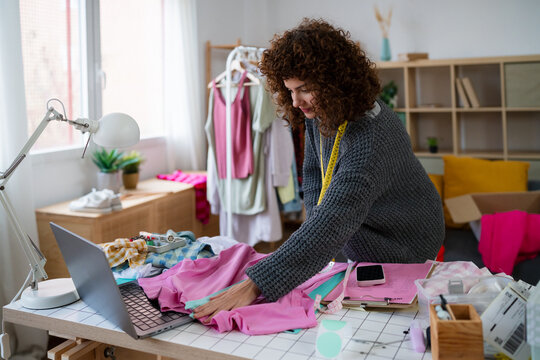 Fashion designer preparing handmade clothing at workspace
