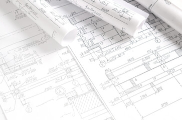 Architect workspace with blueprints, laptop and sketches on bright desk, modern design studio for CAD and planning, minimal clean office background with copy space and daylight.