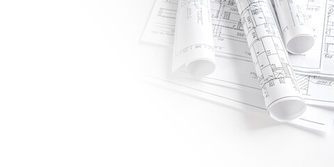 Architect workspace with blueprints, laptop and sketches on bright desk, modern design studio for CAD and planning, minimal clean office background with copy space and daylight.