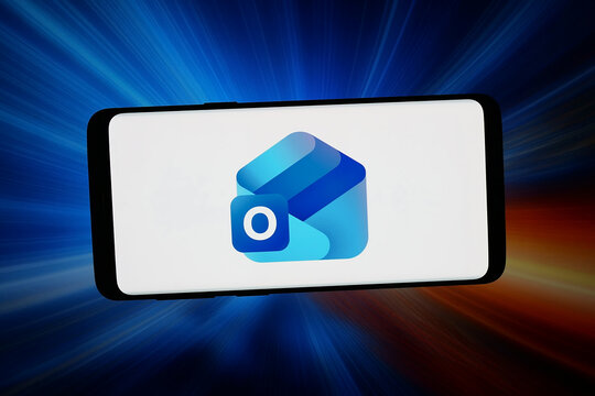 Stuttgart, Germany - 03-02-2026: In this photo illustration, the logo of email client software Microsoft Outlook is displayed on a smartphone in front of abstract background on computer screen.
