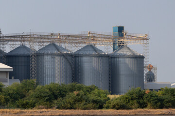 Obraz premium Metal silos stand tall against a clear sky