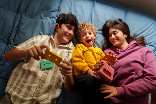 Family enjoying music and cassette tapes together on a bed