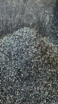 Metal chips cascade into the chip tray of a metalworking machine during machining, collecting waste for efficient cleanup and safety.