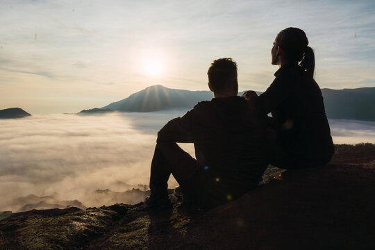 Couple enjoying sunrise at Mount Bromo volcano with scenic misty landscape