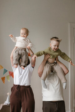 Parents lift children during joyful family celebration at home