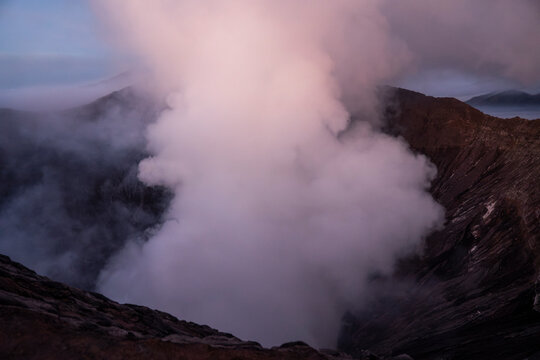 Dramatic sunrise view of Mount Bromo volcano crater with smoke in Java