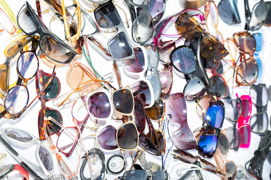 Assortment of various sunglasses in a pile at a flea market