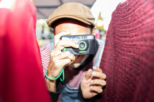 Photographer with disposable analog camera in close-up having fun