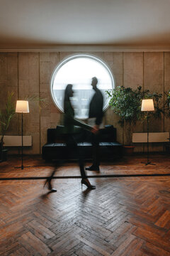 Businesspeople walking in stylish office interior with motion blur