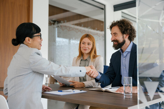 Handshake between business partners in modern office meeting