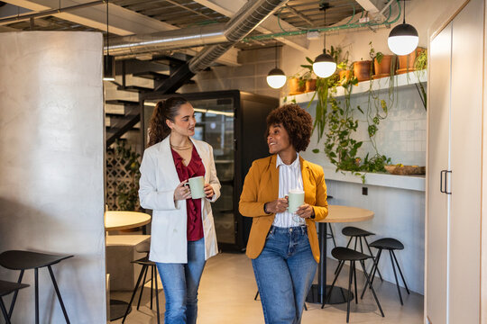Coworkers having coffee and conversation during office break
