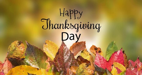 Fototapeta premium Showing autumn leaves pile with centered Happy Thanksgiving Day text on card, warm bokeh backdrop