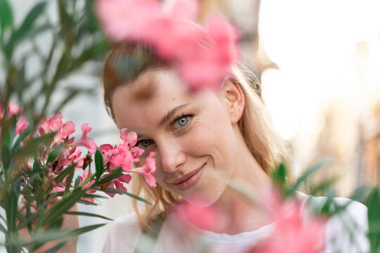 Portrait of young wiman with pink oleander flowers