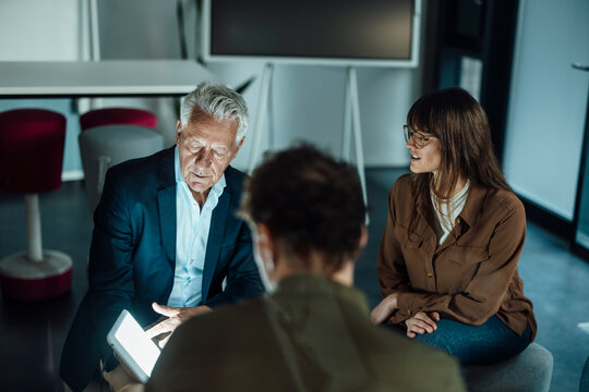 Business team collaborating in modern office during overtime meeting
