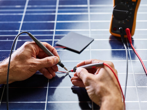 Technician measuring resistor of silicon solar cell