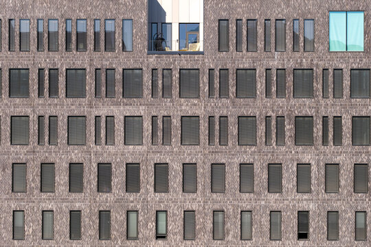 Brick windows across a modern facade form an urban grid pattern with strong symmetry in clean architecture building detail texture background