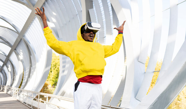 Carefree sportsman using virtual reality headset while standing on walkway