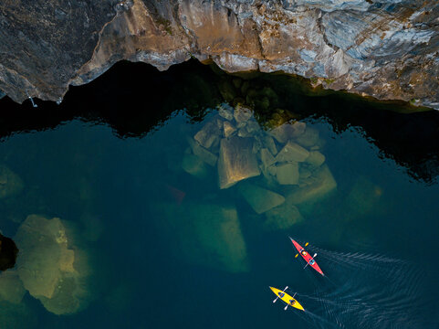 Russia, Republic of Karelia, Sortavala, Aerial view of kayakers sailing over sunken boulders in Lake Light