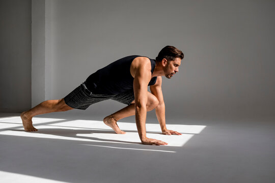 Athlete worming up in sunlit studio