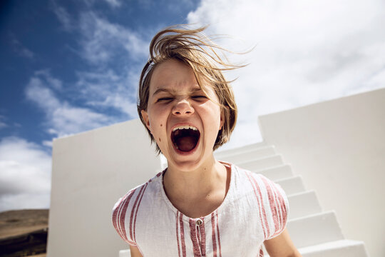 Girl with windswept hair, screaming out loud