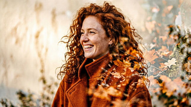 Happy young woman with red curly hair in autumn outerwear