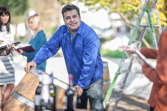Wine barrel worker with saleswoman outdoors
