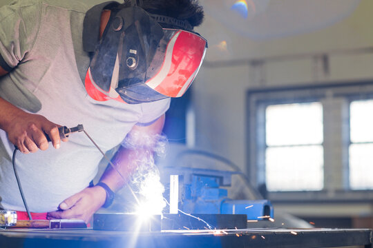 Mechanic welding in car workshop