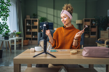 Woman recording beauty tutorial using jade roller for social media © Miljan Živković