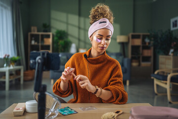 Woman recording beauty tutorial using jade roller for social media © Miljan Živković