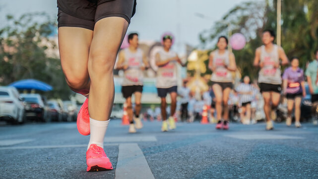 Focused shot of a female runner's feet competing in a crowded fun run