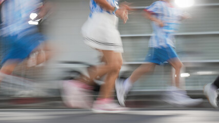 Fototapeta premium Fast-paced action shot of people running, abstract sports background