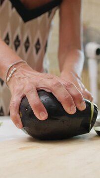 A woman cuts homemade eggplants on a cutting board to make Sicilian parmigiana