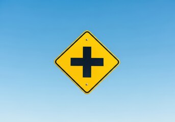 Fototapeta premium Yellow diamond intersection warning sign against a clear sky, symbolizing traffic regulation and safety guidance for upcoming roads ahead, post, warning sign, transportation