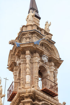 The top part of magnificent Baroque facade of Church of the Santos Juanes, featuring the ornate clock tower, bell gable, and statues of saints.Valencia, Spain