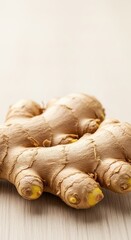 Fototapeta premium A macro shot showing the knobby texture and rough skin of a large piece of fresh ginger root, resting on a natural wooden surface, traditional, fresh, texture